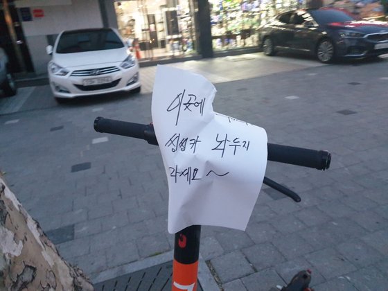 서울 강남의 한 길거리에 아무렇게나 방치된 공유 전동 킥보드. '이곳에 씽씽카 놔두지 마세요'란 경고 문구를 지나던 주민이 붙여 놓았다. [독자 제공]