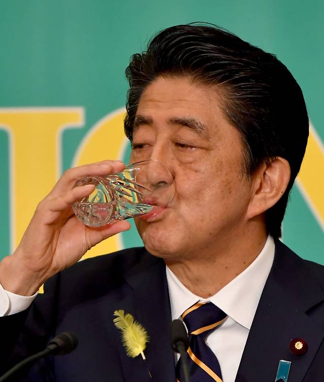 △물먹는 아베…아베 신조 일본 총리가 3일 도쿄 프레스클럽에서 열린 당대표 토론회에서 물을 마시고 있다. [사진=AFP제공]