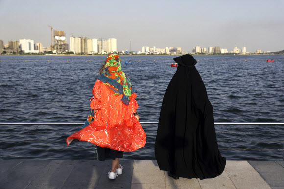 지난 6일 이란 수도 테헤란의 순교자의 호수 주변에서 두 여성이 오후 시간을 즐기고 있다. 두 여성의 복장이나 히잡이 대조적이다. AP연합뉴스