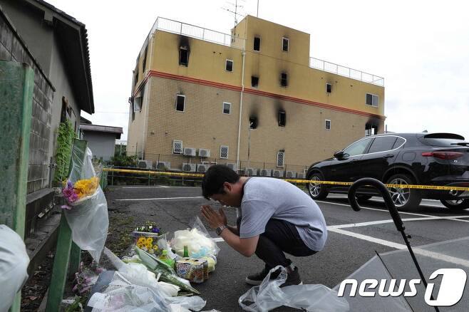 일본 '교토 애니메이션' 방화 현장에 한 남성이 희생자들을 추모하고 있다. © AFP=뉴스1