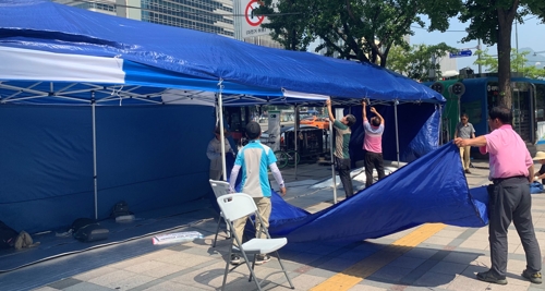 우리공화당 당원들이 19일 서울 중구 서울파이낸스센터 빌딩 앞에 설치했던 천막을 철거하고 있다. [촬영 한지은 기자]