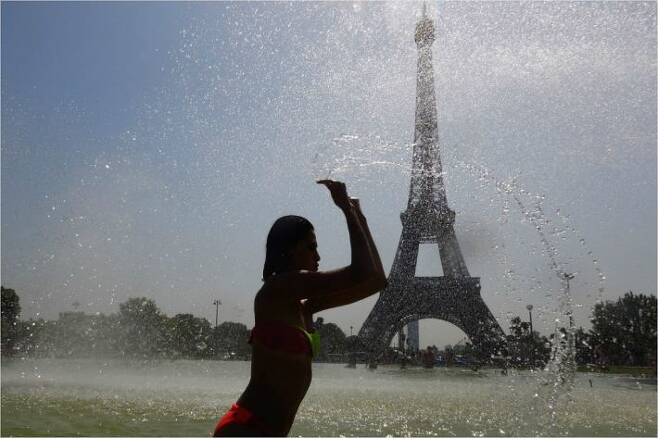 프랑스 파리의 에펠탑을 배경으로 분수대에서 더위를 식히는 여성(사진=AFP/연합뉴스)