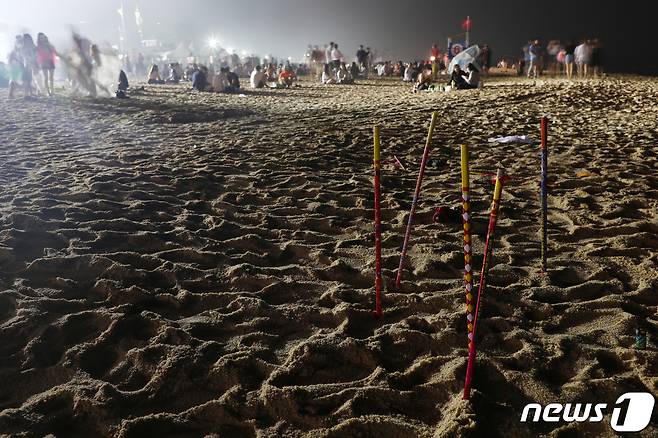 지난 1일 강릉 경포해변에서 관광객들이 쓰고 버린 폭죽이 모래사장에 꽂혀 있다.2019.08.01/뉴스1 © News1 이찬우 기자