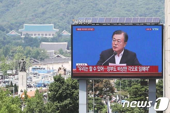 (서울=뉴스1) 이승배 기자 = 일본이 한국을 전략물자 수출심사 우대국(화이트리스트)에서 제외한 2일 오후 서울 중구 프레스센터 앞 대형 옥외광고판에 생중계되는 문재인 대통령의 임시 국무회의 모두발언 화면 뒤로 청와대가 보이고 있다. 2019.8.2/뉴스1 <저작권자 © 뉴스1코리아, 무단전재 및 재배포 금지>
