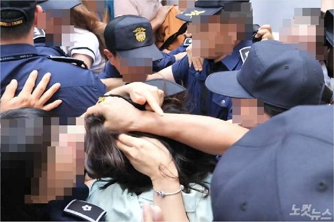 피고인 고유정이 12일 재판이 끝난 뒤 호송차에 올라타는 과정에서 한 시민에게 머리채를 잡히고 있다. (사진=고상현 기자)