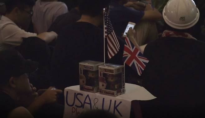 홍콩 반송환법 시위대가 16일(현지시간) 집회를 열고 있다.  국제적 지지를 호소하기 위해 들고 나온 미국과 영국 국기가 보인다.