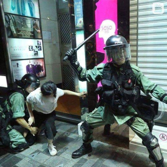 지난 10일 홍콩 침사추이 시위 현장에서 흰색 옷을 여성이 시위에 참여하지 않았음에도 무장 경찰에 체포됐다. 과잉 진압 논란을 불러일으킨 무장 경찰은 홍콩 경찰은 하지 않는 자세를 취해 의혹을 키웠다.[페이스북 캡쳐]