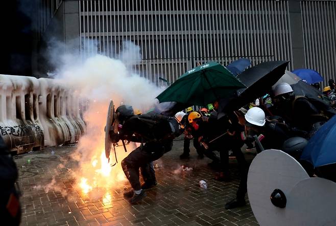 31일 시위 도중 경찰이 쏜 최루탄을 우산으로 막고 있는 시위대. /사진=로이터통신