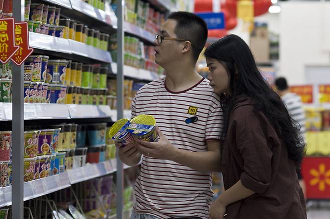 중국의 한 슈퍼마켓 진열대에서 남녀가 라면을 고르고 있다.                                                                                                     사진 남방주말