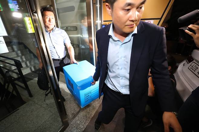 지난달 27일 저녁 서울 강남구의 한 빌딩에서 검찰 관계자들이 조국 법무부 장관 후보자 가족이 투자한 사모펀드 운용사 코링크프라이빗에쿼티 사무실의 압수수색을 마친 뒤 압수품들을 차량으로 옮기고 있다. 연합뉴스