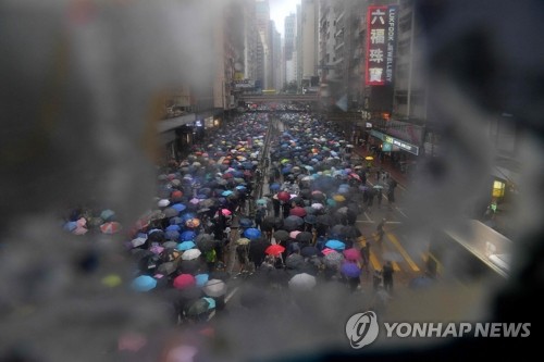 홍콩의 빗속 시위 (홍콩 AP=연합뉴스) 홍콩 정부의 '복면금지법' 시행에 반대하는 시위자들이 6일 비가 내리는 가운데 홍콩 쇼핑가 코즈웨이베이에서 우산을 쓴 채 행진하고 있다. bulls@yna.co.kr