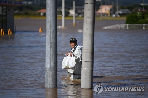식료품 들고 침수지역 지나는 日 봉사자 (시바타 AFP=연합뉴스) 태풍 '하기비스'가 강타한 일본 미야기현 시바타에서 지난 13일 한 남성이 침수로 고립된 주민들에게 제공할 식료품을 들고 홍수 지역을 지나고 있다.