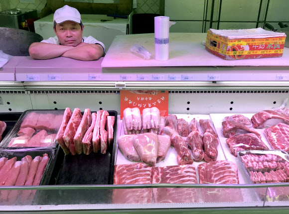 중국 베이징의 한 슈퍼마켓에서 돼지고기 판매업자가 안타까운 표정으로 손님을 기다리고 있다.서울신문 DB