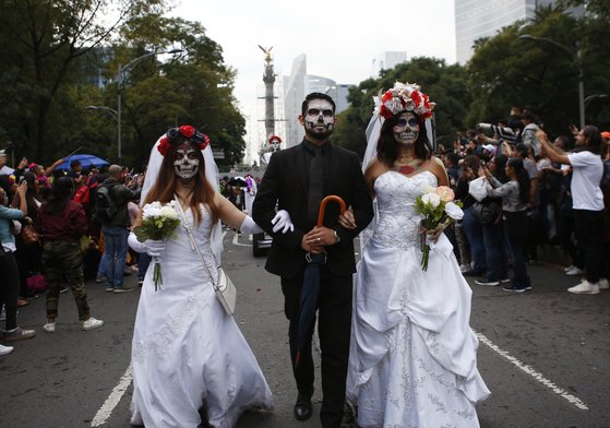 웨딩 드레스를 입은 사람들이 지난 26일(현지시간) 멕시코의 수도 멕시코시티에서 열린 죽음의 날 퍼레이드에 참가하고 있다. [AP=연합뉴스]