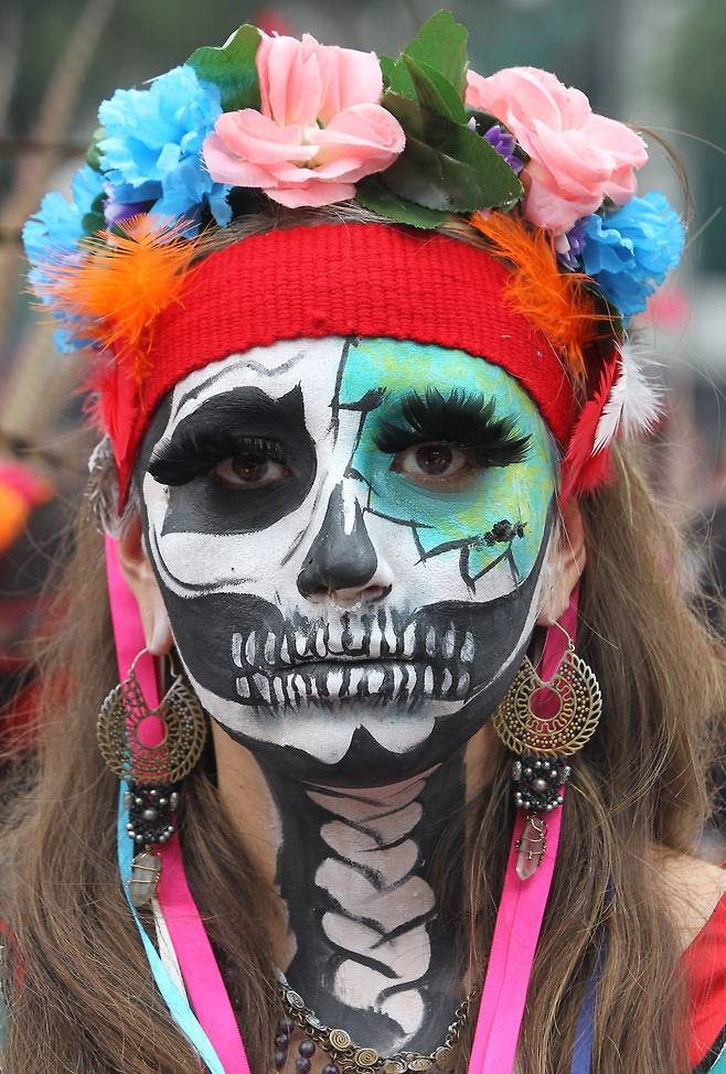 지난 26일(현지시간) 멕시코 멕시코시티에서 한 여성이 해골 모양으로 얼굴을 페인트하고 죽음의 날 퍼레이드에 참가하고 있다. [ EPA=연합뉴스]
