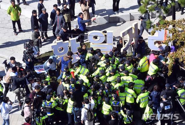 【부산=뉴시스】 하경민 기자 = 아베규탄부산시민행동 등 부산지역 시민사회단체 회원들이 30일 오전 부산 동구 정발 장군 동상 앞에 설치된 강제징용 노동자상 앞 화단에 '항일거리' 현판을 설치하려다 경찰병력과 충돌하고 있다. 2019.10.30. yulnetphoto@newsis.com