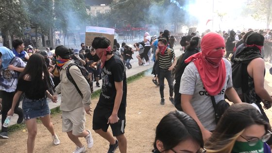 대규모 반정부 시위 19일째를 맞은 11월 5일(현지시간) 칠레 수도 산티아고 시내 이탈리아광장에서 시위대가 경찰의 물대포와 최루탄을 피해 도망가고 있다. [이광조 JTBC 촬영기자]