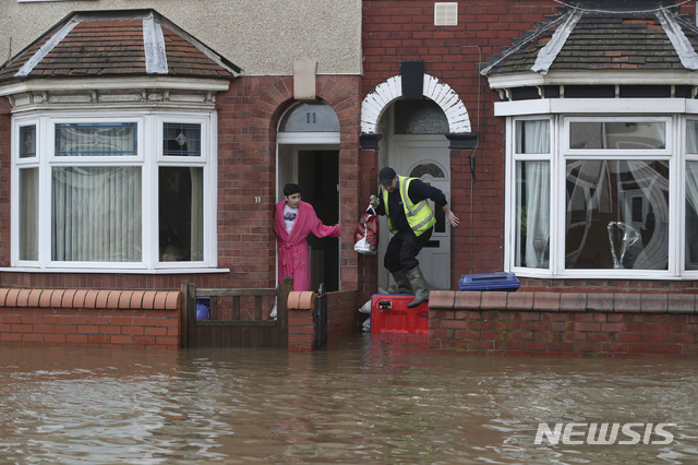 【동커스터=AP/뉴시스】8일(현지시간) 영국 잉글랜드 중북부 동커스터의 한 주거지역에서 시민들이 폭우로 범람한 도로를 바라보고 있다. 2019.11.8.