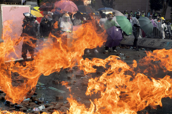 - 17일 홍콩 이공대에서 경찰의 진압에 맞선 시위대가 화염병으로 불타고 있는 바닥을 바라보고 있다. 2019.11.17 AP 연합뉴스