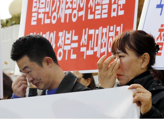 북한인권단체총연합의 탈북자들이 12일 서울 종로구 정부서울청사 앞에서 '귀순 탈북자 강제추방 규탄' 기자회견 중 눈물을 흘리고 있다. 뉴시스