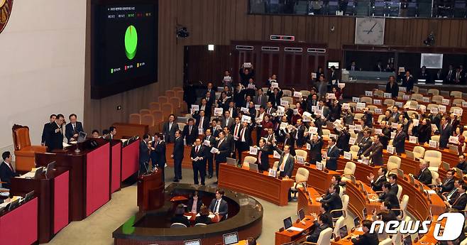 10일 서울 여의도 국회 본회의장에서 열린 제371회국회(정기회) 제12차 본회의에서 문희상 국회의장이 2020년도 예산안을 상정 의결하고 있다. 자유한국당 의원들이 '날치기' 피켓을 들고 '아들공천'을 외치며 발언대를 점거하고 있다. 2019.12.10/뉴스1 © News1 이종덕 기자
