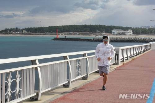 포근한 날씨를 보인 7일 오전 제주시 이호테우해변 해안도로에서 한 시민이 반바지 차림으로 달리기 운동을 하고 있다. 뉴시스