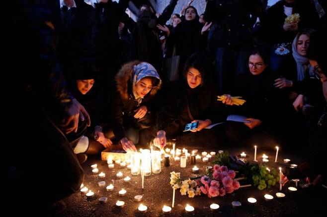 11일 밤(현지시각) 이란 수도 테헤란의 아미르카비르대학 앞에서 시민들이 이란 군의 우크라이나 민항기 오인 격추로 숨진 176명의 희생자들을 추모하는 촛불을 밝히고 있다. 테헤란/AFP 연합뉴스