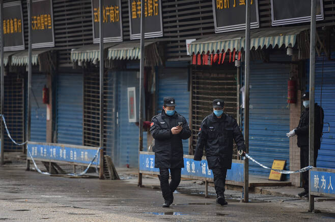 '우한 폐렴'의 진원지인 중국 후베이성 우한시에서 24일 안전요원들이 수산물 도매시장 주위를 순찰하고 있다. [연합]