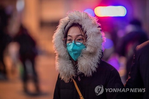 베이징 기차역 앞의 마스크 쓴 여성 (베이징 AP=연합뉴스) 중국에서 신종 코로나바이러스가 일으키는 '우한 폐렴'의 사망자가 급증하는 가운데 마스크를 착용한 한 여성이 22일 베이징 기차역 앞 거리를 걸어가고 있다. leekm@yna.co.kr