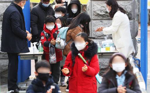 경기도 수원시의 한 초등학교에서 학생들이 신종 코로나바이러스 감염증인 '우한 폐렴' 예방을 위해 마스크를 쓰고 손 소독을 하며 등교하고 있다. 연합뉴스