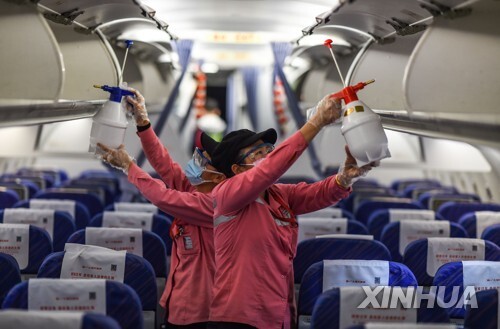 중국 하이난성 하이커우에 도착한 한 항공기에서 방역 작업 중인 직원들 [신화=연합뉴스]