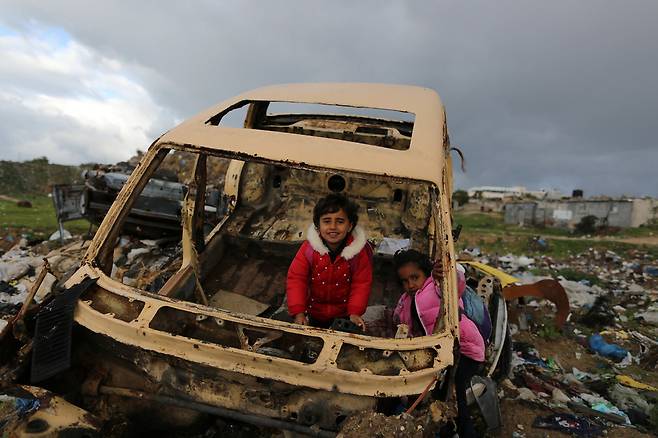 10일 이스라엘 공군이 공습을 단행한 팔레스타인 가자 지구 남부 도시 칸 유니스의 한 마을 공터에서 어린이들이 뼈대만 남은 채 나뒹구는 자동차 잔해에서 놀고 있다. 칸 유니스/신화 연합뉴스