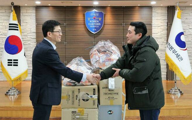 양을수 인천세관 통관지원과 과장(왼쪽)이 한국사회복지협의회 산하 인천 푸드마켓 유현우 사회복지사에게 마스크를 전달하고 있다. (사진=관세청 제공)