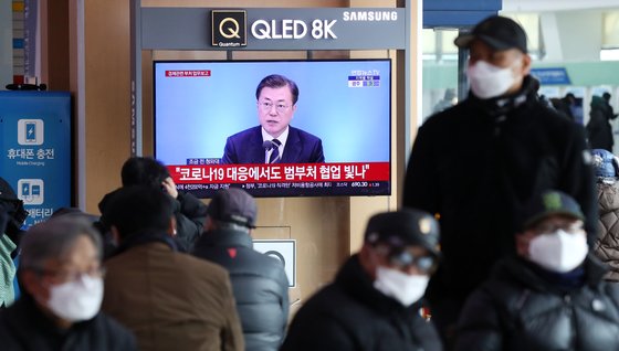 시민들이 지난 17일 서울역 대합실에서 문재인 대통령이 업무보고받는 모습을 지켜보고 있다. [뉴스1]