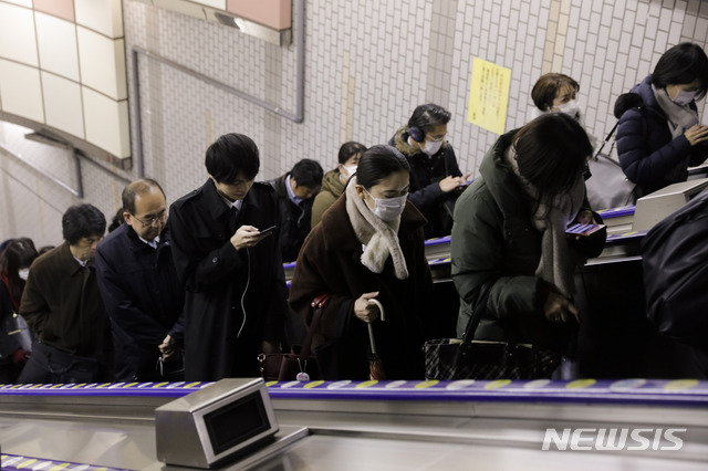 [도쿄=AP/뉴시스]28일 오전 일본 도쿄에서 사람들이 마스크를 쓴 채 출근하고 있다. 2020.01.28.