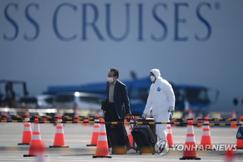 (요코하마 AFP=연합뉴스) 신종 코로나바이러스 감염증(코로나19) 환자가 집단 발생해 일본 요코하마항에 발이 묶인 크루즈선 '다이아몬드 프린세스'호(뒤쪽)에서 한 승선객(왼쪽)이 19일 하선하고 있다.