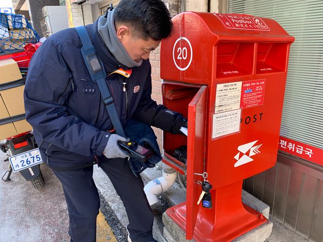 지난 18일, 서울 중구 회현동 우편취급국 앞 우체통에서 우편물을 꺼내는 집배원 김영삼(47) 씨. 이미령 인턴기자.