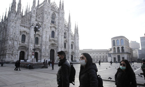 이탈리아 북부 밀라노에서 신종 코로나바이러스 감염증(코로나19) 우려로 마스크를 착용한 사람들이 고딕 대성당인 ''두오모'' 앞을 지나가고 있다. 밀라노=AP연합뉴스