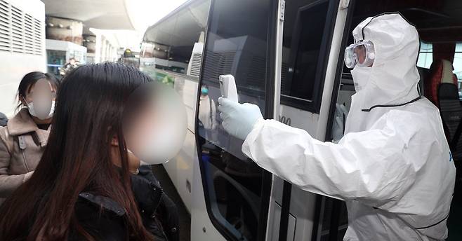 24일 인천국제공항을 통해 입국한 중국인 유학생들이 버스 탑승 전 체온 검사를 받고 있다. 뉴스1