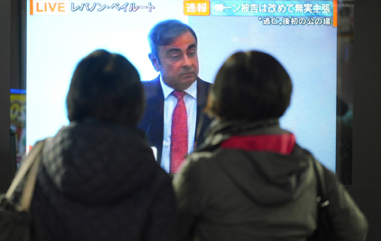 도쿄 시민들이 1월 8일 카를로스 곤의 탈주극을 다룬 방송 뉴스를 보고 있다. [뉴시스]