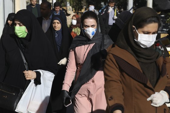 마스크를 쓴 이란인들이 지난 2일 테헤란의 거리를 걷고 있다. 신종 코로나 확진자와 사망자가 폭증한 이란에선 마스크 품귀 현상이 빚어진다. [AP=연합뉴스]