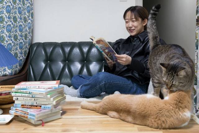 반려묘들과 사는 이마루 작가가 거실에서 순정만화를 보고 있다. 이 작가는 현재 패션잡지 <엘르>의 피처 에디터로 일하고 있다.