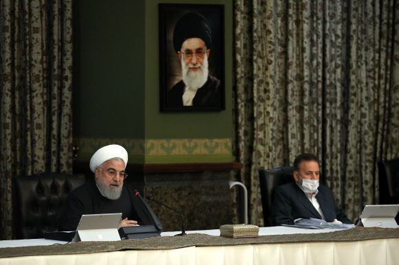 하산 로하니(왼쪽) 이란 대통령이 11일 테헤란에서 내각 회의를 주재하며 열변을 토하고 있다. 위 초상화는 아야톨라 알리 하메네이 최고 지도자의 것이다.이란 대통령궁 제공 AFP 연합뉴스