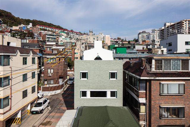 서울 홍은동의 ‘남녀 하우스’의 남측 면은 남성을 상징한다. 창 둘레의 청록색 타일과 조형미를 살린 창이 돋보인다. ©진효숙 건축사진작가