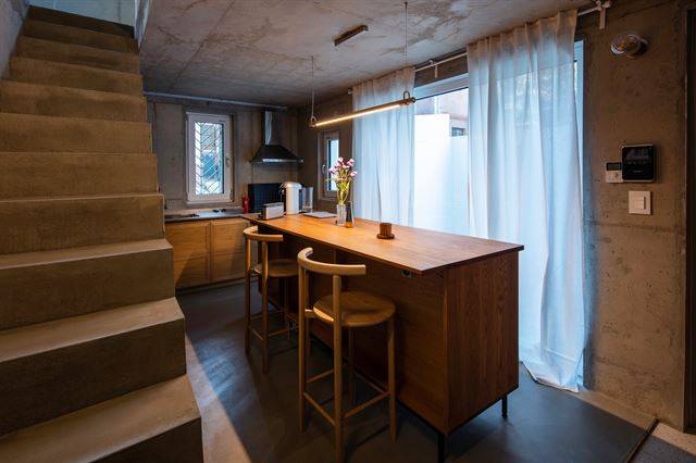 노출 콘크리트 내부의 차가운 느낌을 보완하기 위해 원목 가구를 많이 썼다. 1층 주방의 원목 테이블은 카페 같은 주방을 만들기 위해 일부러 사이즈를 크게 했다. ©진효숙 건축사진작가