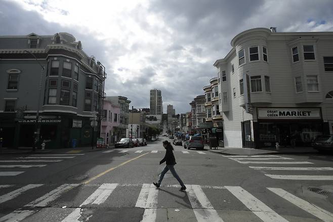 21일(현지시간) 미국 캘리포니아주 샌프란시스코 거리를 행인이 지나고 있다. 주 정부가 주민 4000만명에게 이동금지령을 내리면서, 주말임에도 거리는 한산했다.  샌프란시스코 | AP연합뉴스