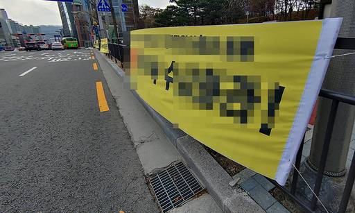 지난 20일 서울 서초구 반포대로 서초역 인근 안전 펜스에 걸린 현수막은 강풍에 찢어질 듯 펄럭이고 있다.