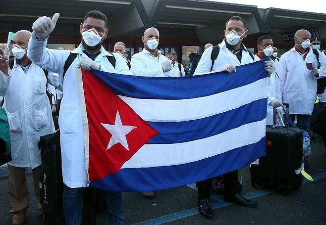 22일 이탈리아 북부 밀라노의 말펜사 국제공항에 쿠바가 파견한 ‘코로나19 퇴치’ 긴급 의료 지원팀이 도착하고 있다. 밀라노/EPA연합뉴스