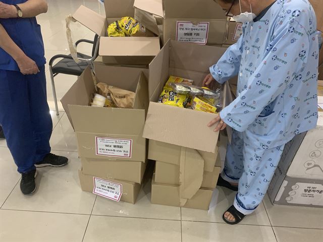 제이미주병원 의료진들이 11층 로비에서 환자복을 입고 전달된 구호물품을 살펴보고 있다. 이들 의료진들은 "음식을 취사할 수 있는 도구도 없고, 생쌀만 씹는 격"이라고 말했다. 제이미주병원 제공