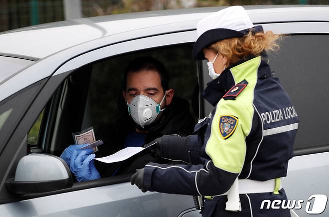 이탈리아 남부 몰페타에서 경찰관이 운전자의 신원을 확인하고 있다. © 로이터=뉴스1
